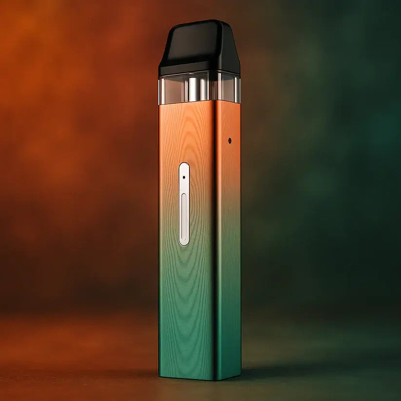 A sleek, modern Vaporesso XROS Mini 16W pod kit vape device with a metallic gradient finish transitioning from orange at the top to teal at the bottom, standing upright against a soft, blurred background of matching warm and cool tones